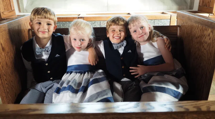 A group of 4 kids in an alter pew