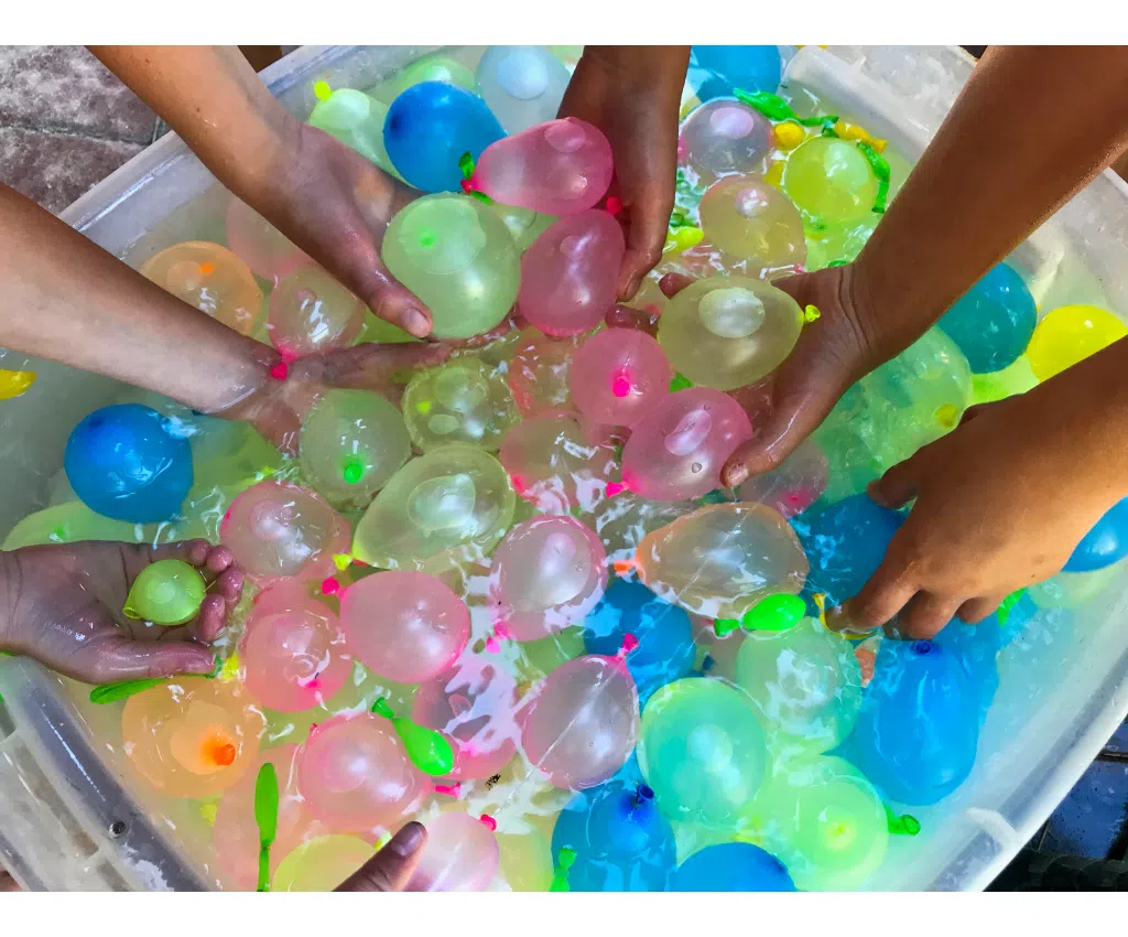campers reaching into a cooler for water balloons