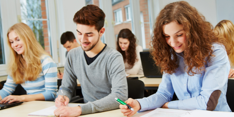 adults sitting at tables taking notes for a class