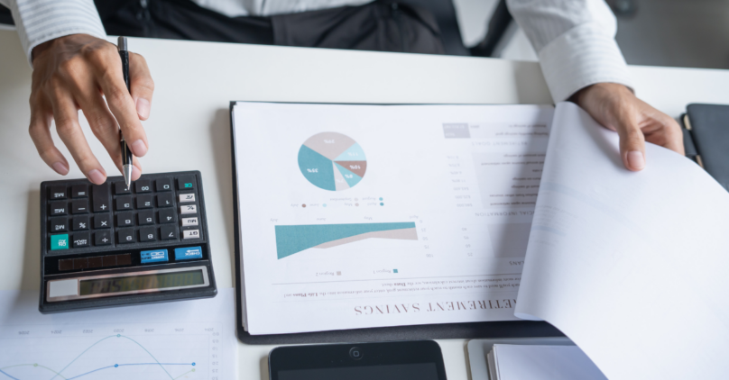 clipboard on a table with a pie chart and graph