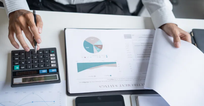 clipboard on a table with a pie chart and graph